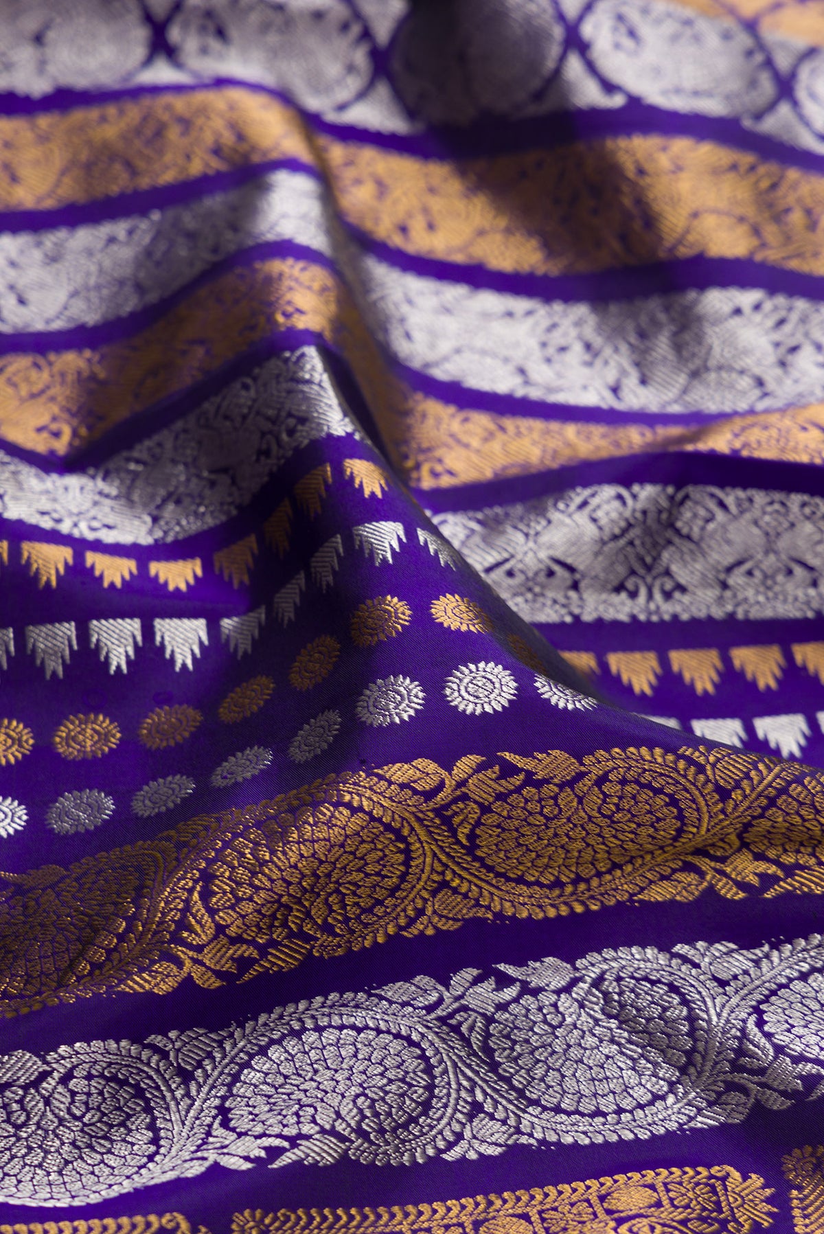 Close up of Pure Silk Dark Blue Kanjivaram Saree with Zari Butta on the body and Plain Border.  displaying folds