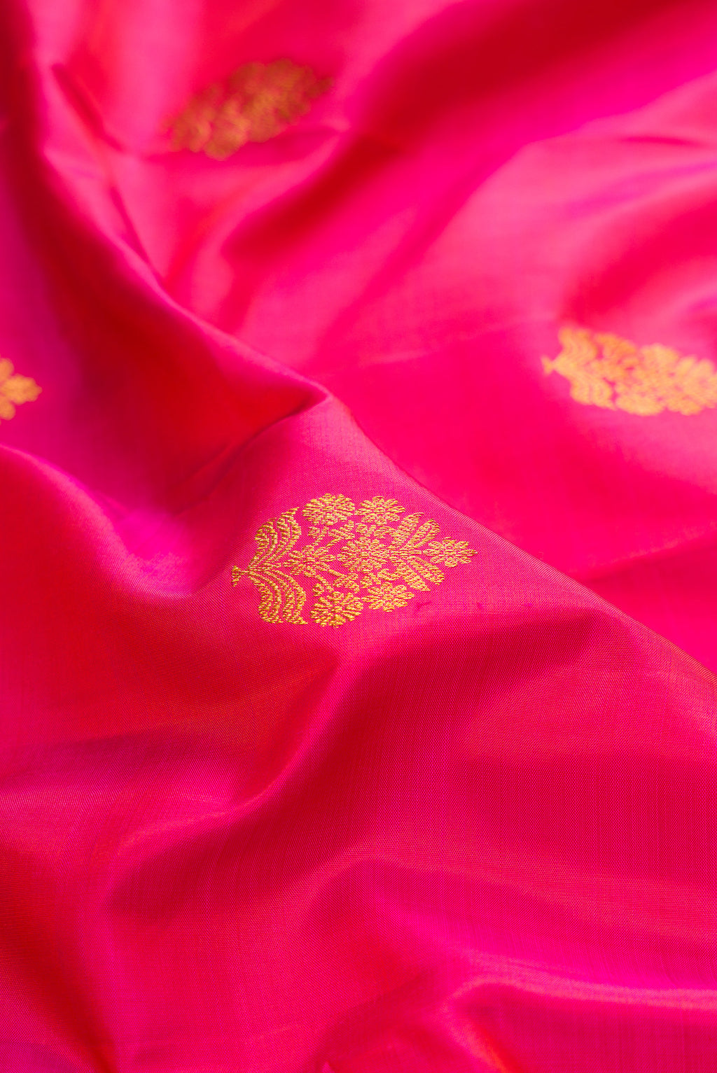 Close up of Pure Silk Dark Pink Dual Tone Kanjivaram Saree with Zari Butta on the body and Zari Border.  displaying folds