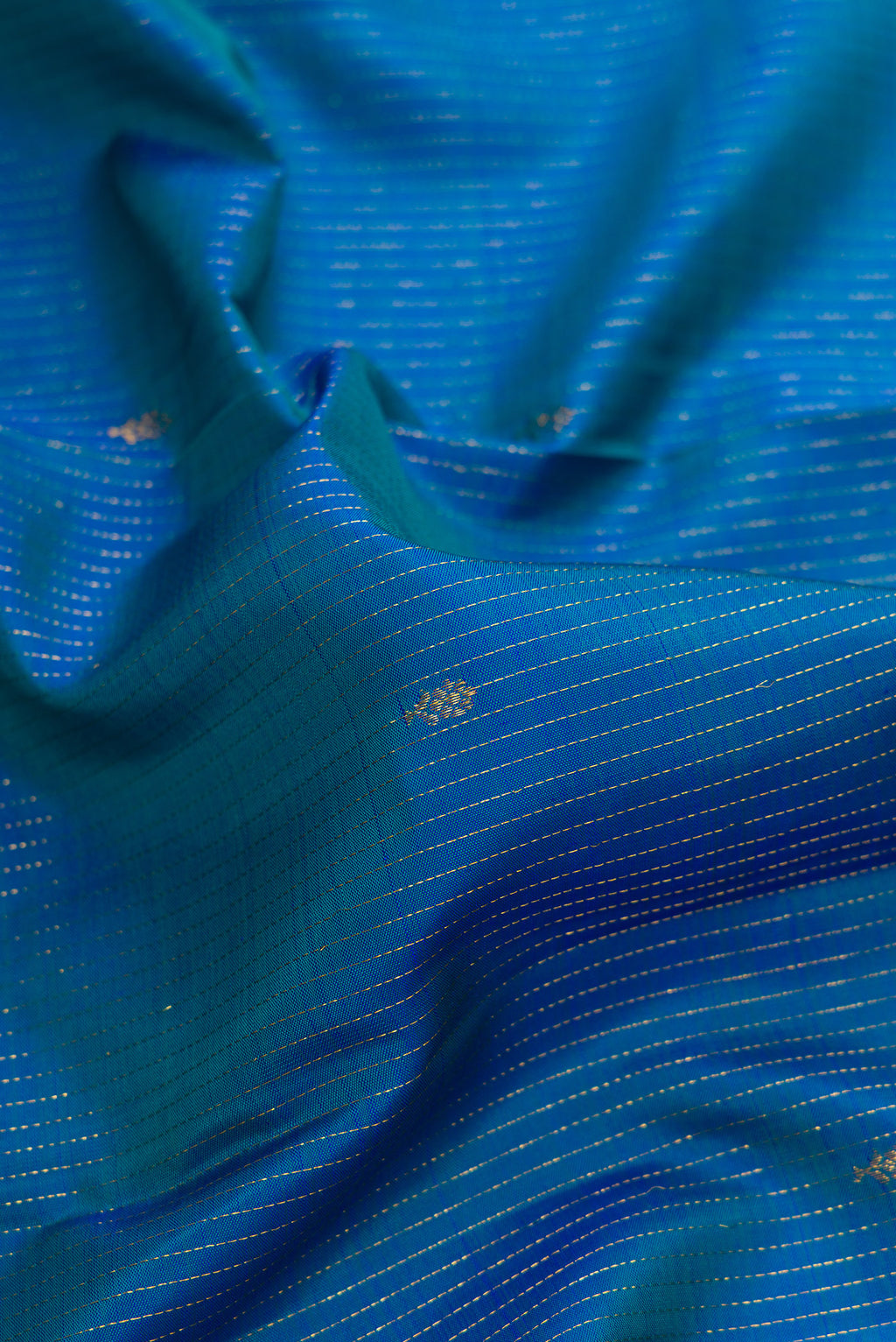 Close up of Pure Silk Peacock Blue Dual Tone Kanjivaram Saree with Stripes on the body and Zari Border.  displaying folds