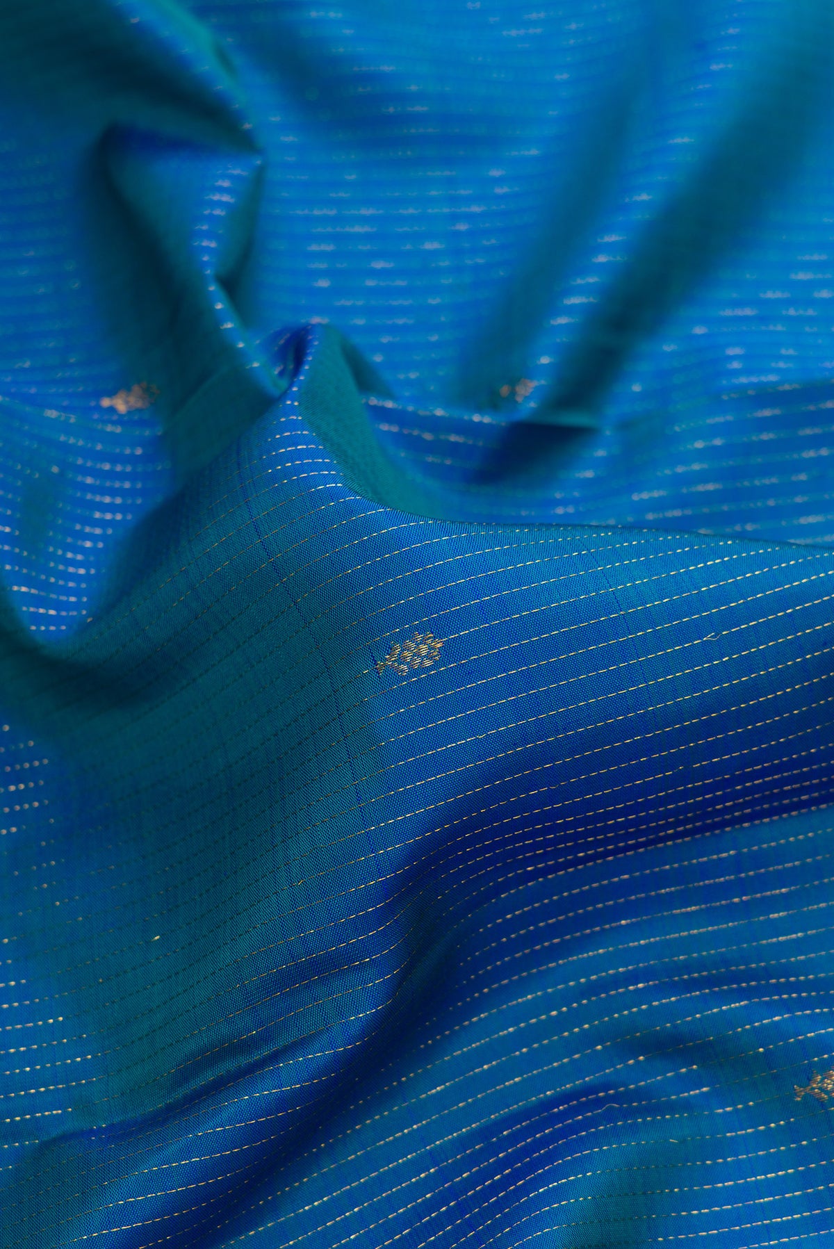 Close up of Pure Silk Peacock Blue Dual Tone Kanjivaram Saree with Stripes on the body and Zari Border.  displaying folds