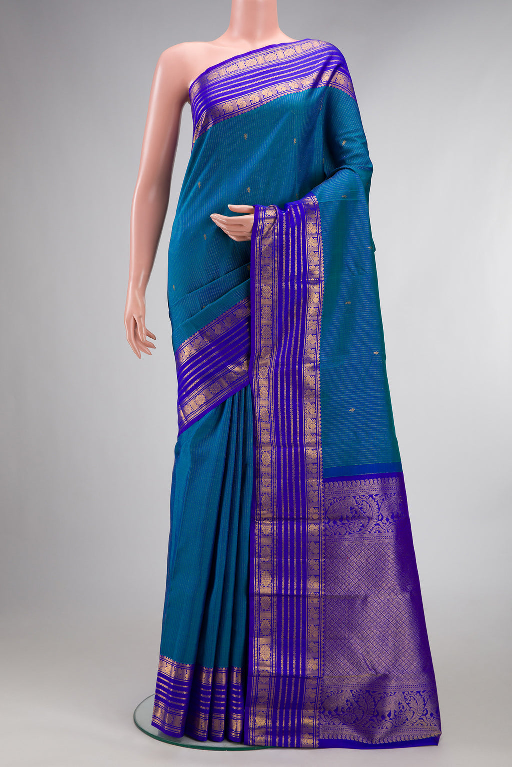 Pure Silk Peacock Blue Dual Tone Kanjivaram Saree with Stripes on the body and Zari Border.  displayed on a mannequin
