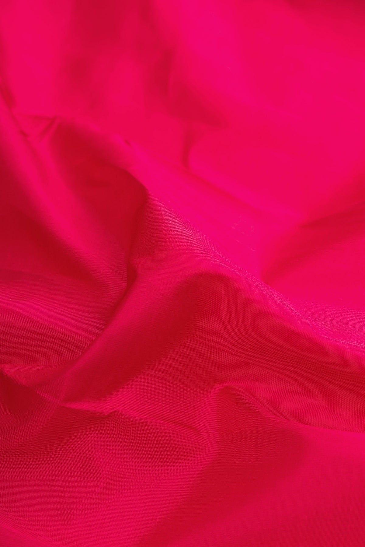 Close up of Pure Silk Dark Pink Dual Tone Kanchipuram Saree with Plain Body and Fancy Border.  displaying folds