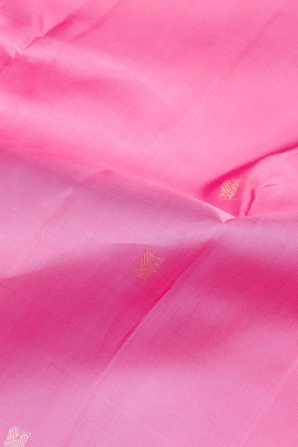 Close up of Pure Silk Rose pink Kanchipuram Saree with Zari Butta on the body and Zari Border.  displaying folds