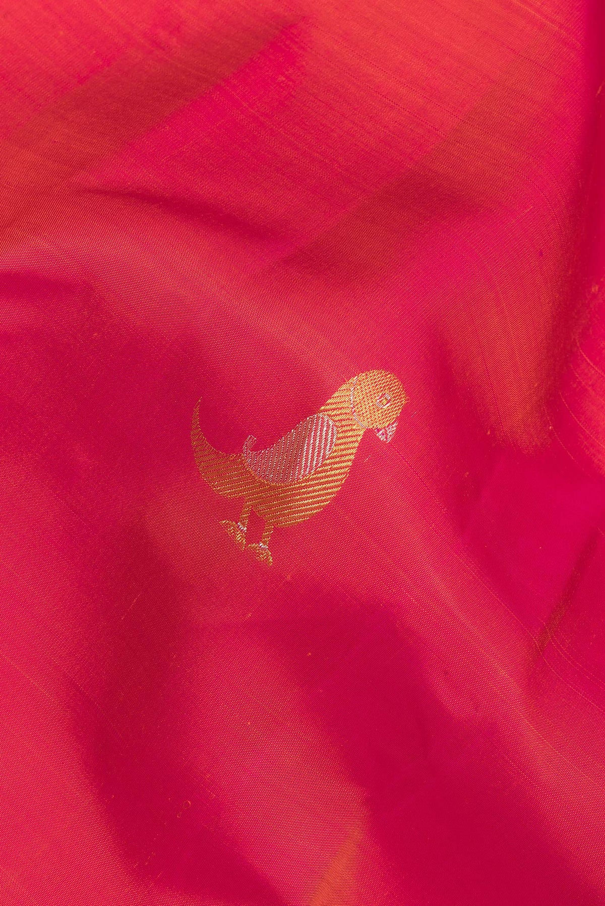 Close up of Pure Silk Red Dual Tone Kanchipuram Saree with Zari Butta on the body and Without Border.  displaying folds