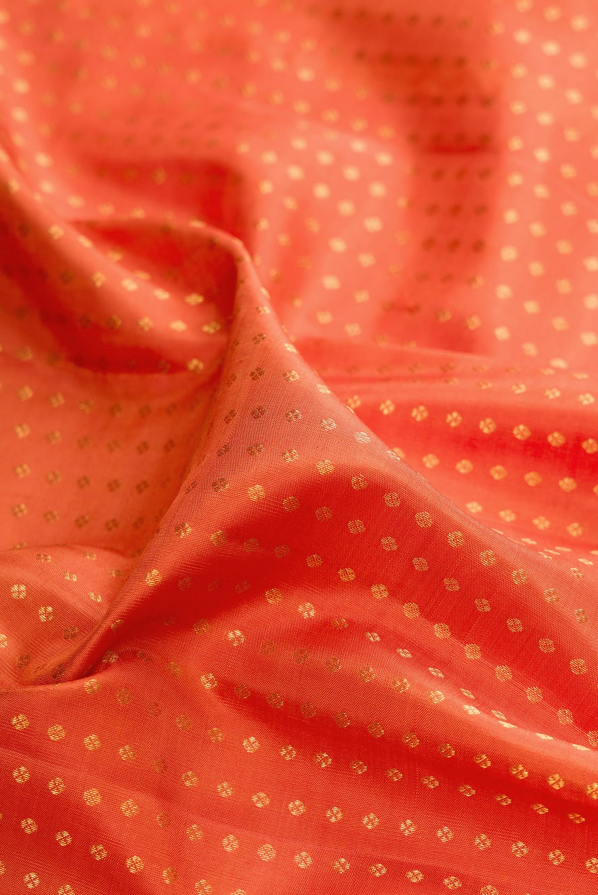Close up of Pure Silk Brick Orange Kanchipuram Saree with Zari Butta on the body and Zari Border.  displaying folds