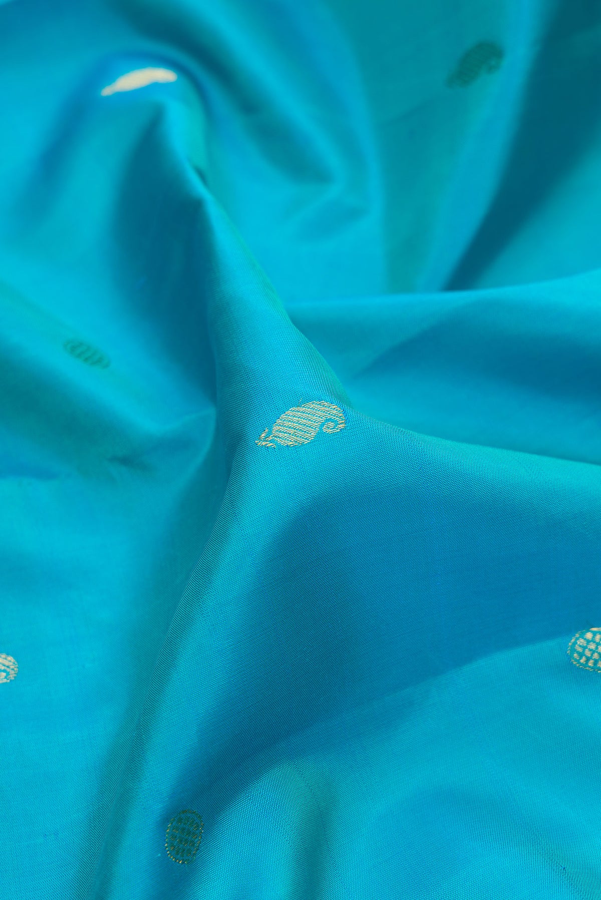 Close up of Pure Silk Sky Blue Kanjivaram Saree with Zari Butta on the body and Fancy Border.  displaying folds