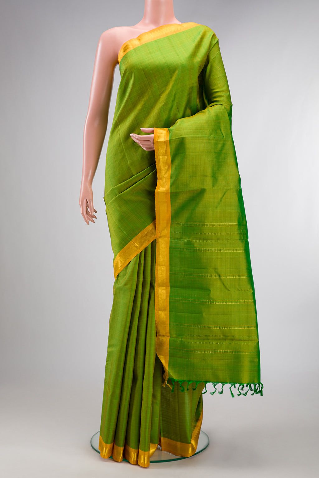 Pure Silk Green Kanchipuram Saree with Plain Body and Zari Border.  displayed on a mannequin