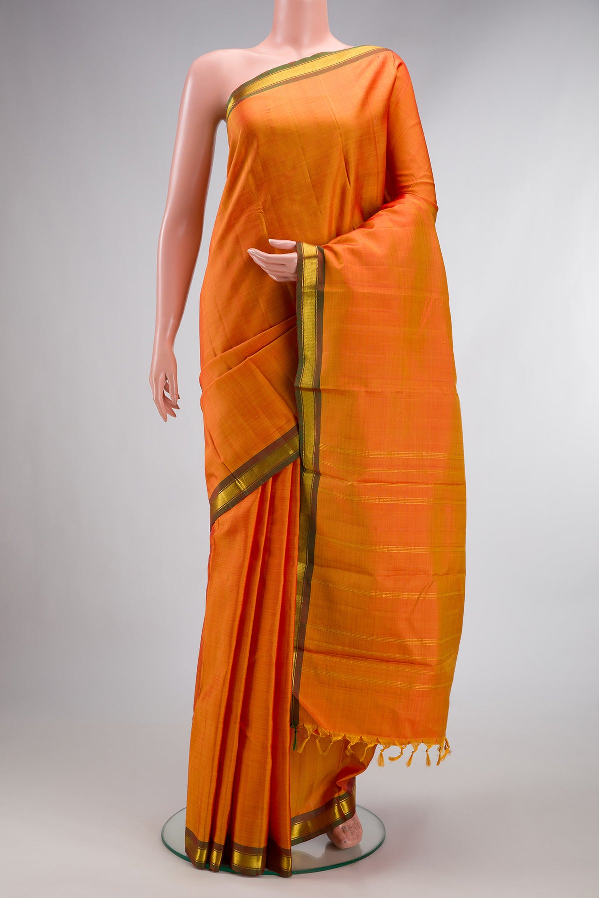 Pure Silk Orange Dual Tone Kanchipuram Saree with Plain Body and Zari Border.  displayed on a mannequin