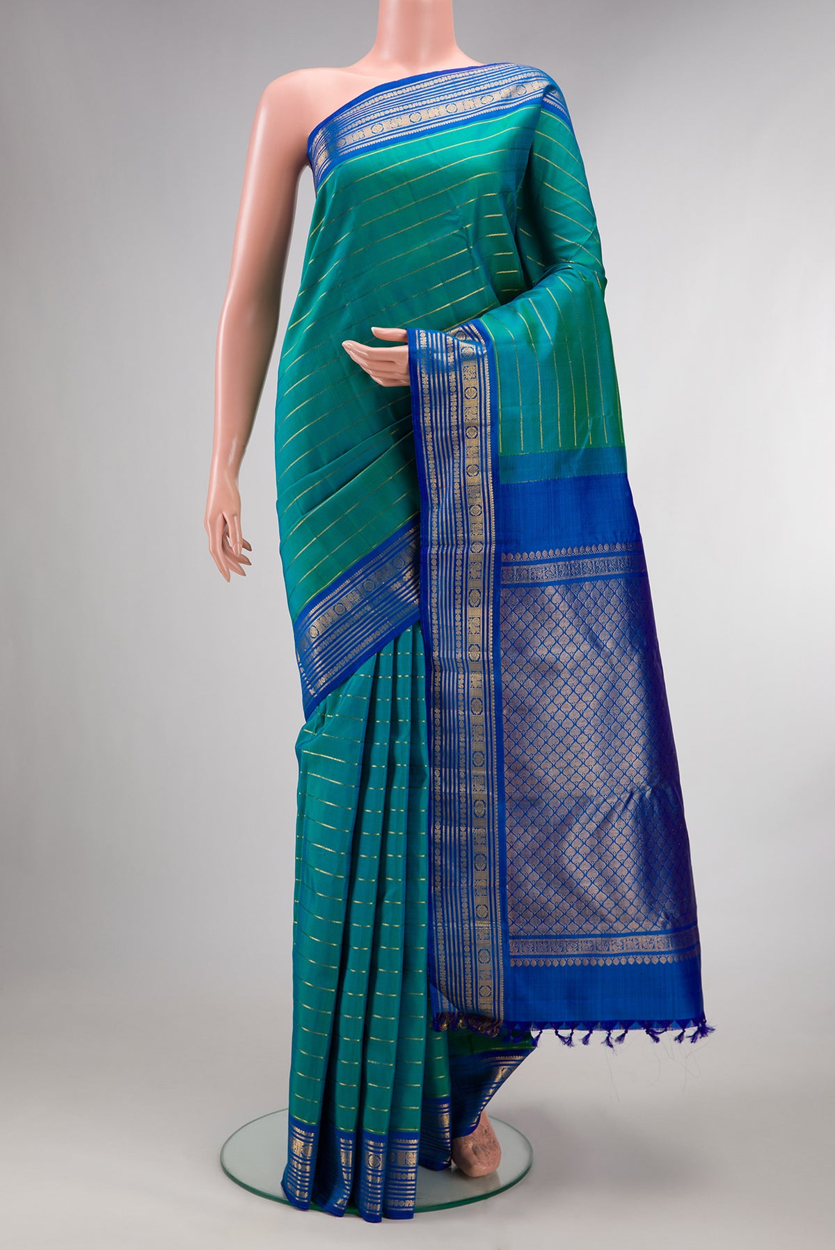 Pure Silk Peacock Blue Dual Tone Kanchipuram Saree with Veldhari on the body and Zari Border.  displayed on a mannequin
