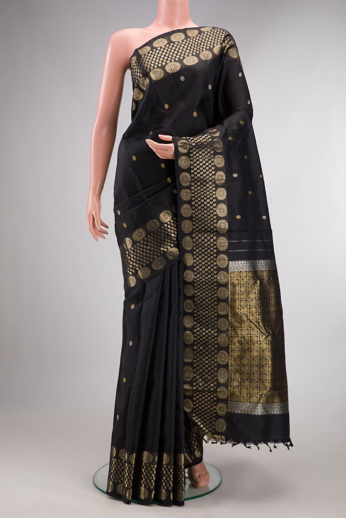 Pure Silk Black Kanjivaram Saree with Zari Butta on the body and Fancy Border.  displayed on a mannequin