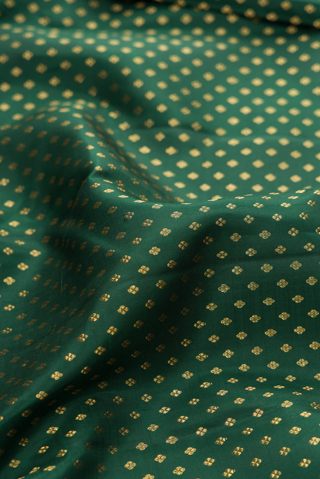 Close up of Pure Silk Green Kanjivaram Saree with Zari Butta on the body and Zari Border.  displaying folds