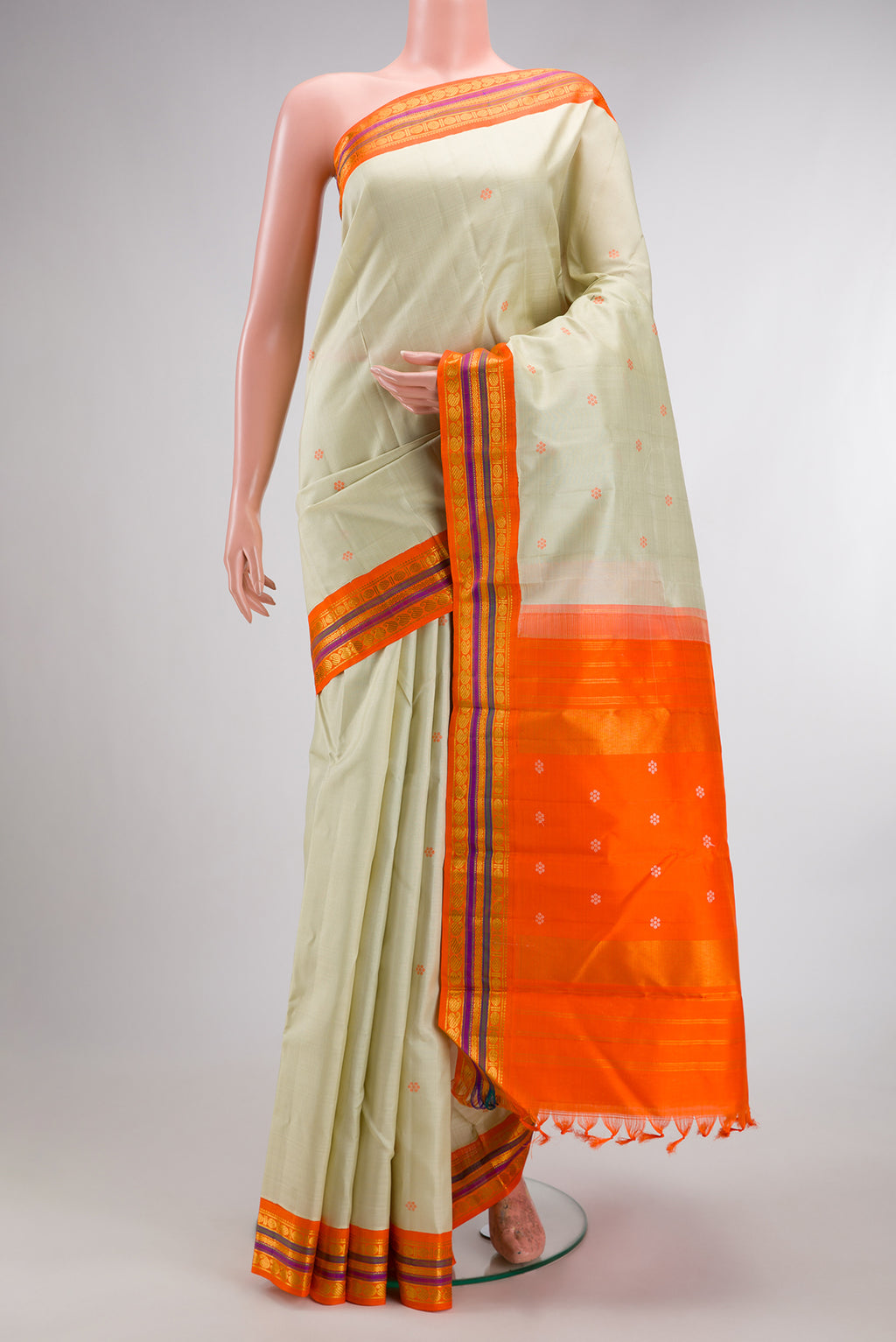 Pure Silk Pista Green Kanjivaram Saree with Thread Butta on the body and Zari Border.  displayed on a mannequin