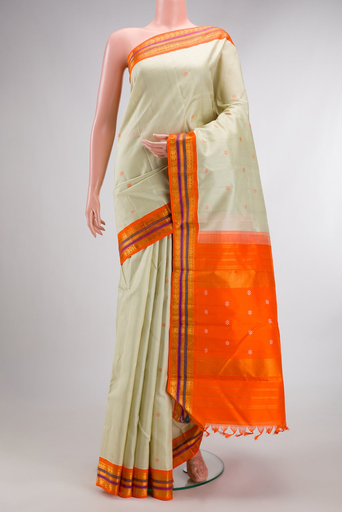 Pure Silk Pista Green Kanjivaram Saree with Thread Butta on the body and Zari Border.  displayed on a mannequin