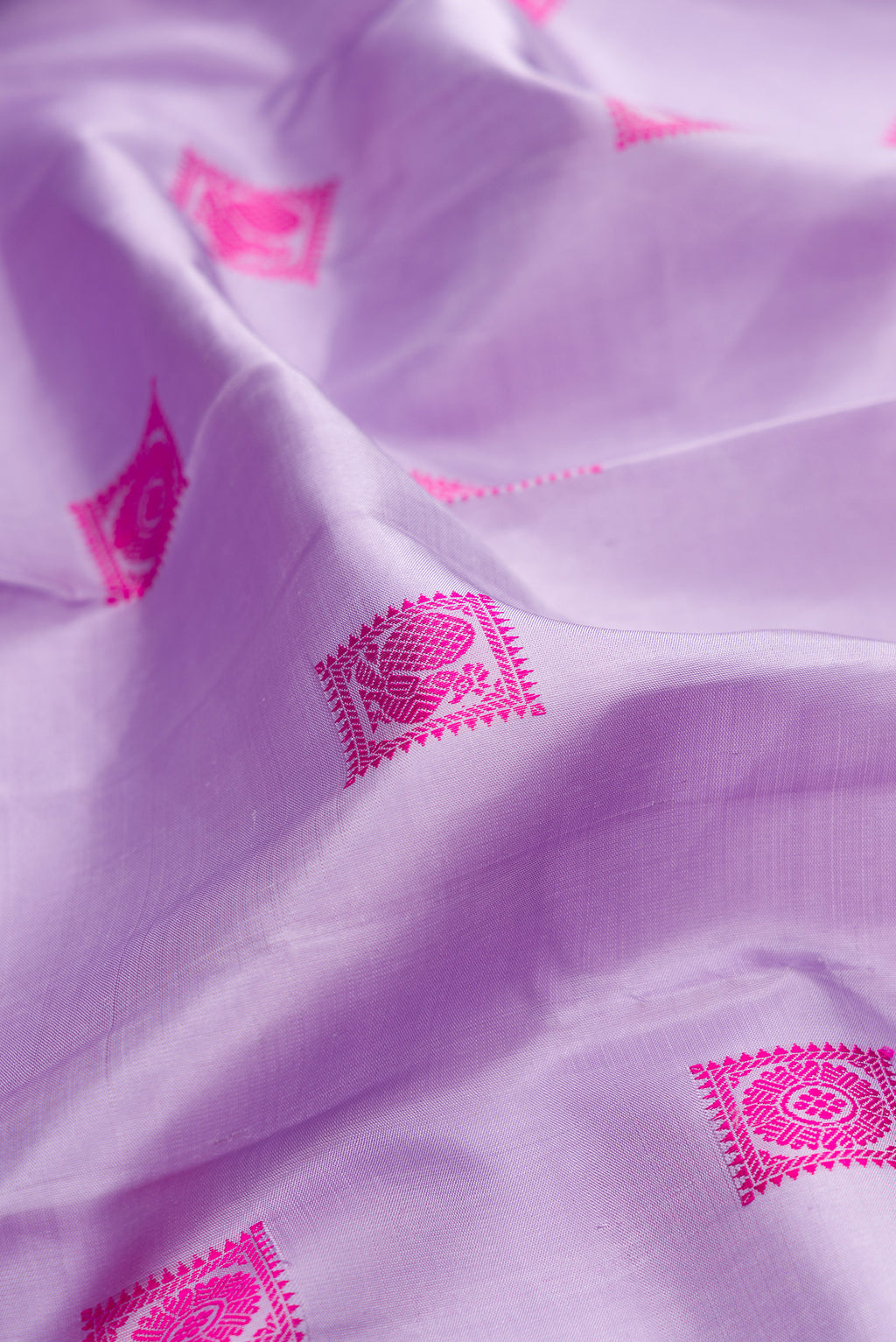 Close up of Pure Silk Lavender Kanjivaram Saree with Thread Butta on the body and Zari Border.  displaying folds