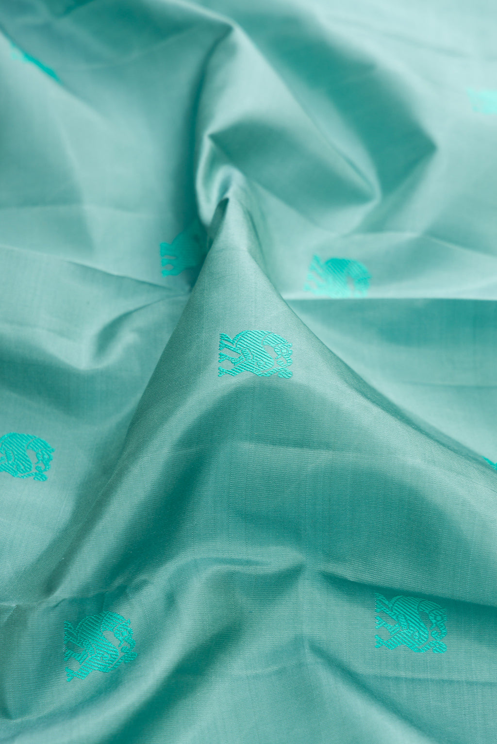 Close up of Pure Silk Turquoise Dual Tone Kanjivaram Saree with Thread Butta on the body and Fancy Border.  displaying folds