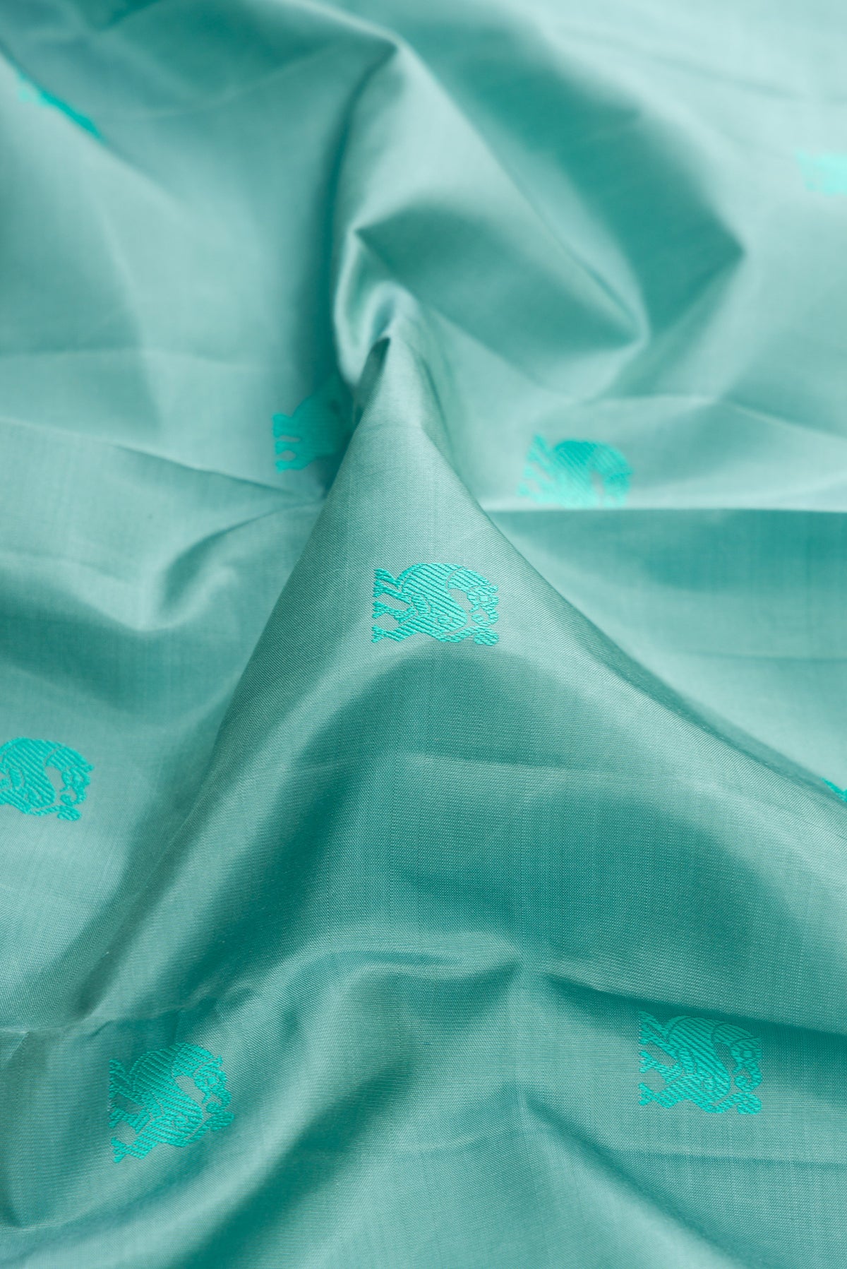 Close up of Pure Silk Turquoise Dual Tone Kanjivaram Saree with Thread Butta on the body and Fancy Border.  displaying folds