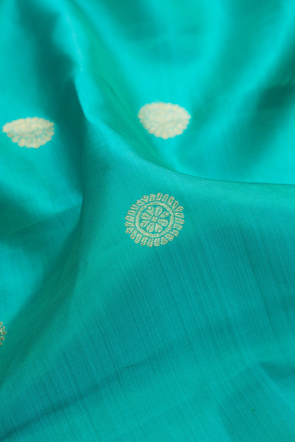 Close up of Pure Silk Sea Green Dual Tone Kanjivaram Saree with Zari Butta on the body and Fancy Border.  displaying folds