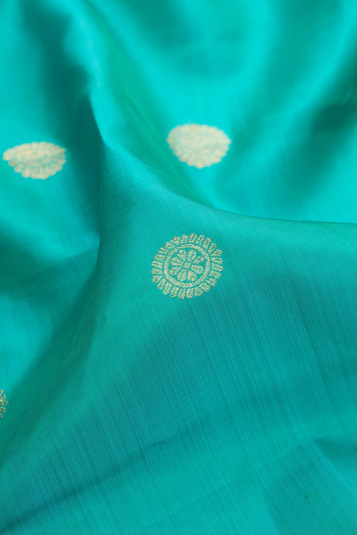 Close up of Pure Silk Sea Green Dual Tone Kanjivaram Saree with Zari Butta on the body and Fancy Border.  displaying folds