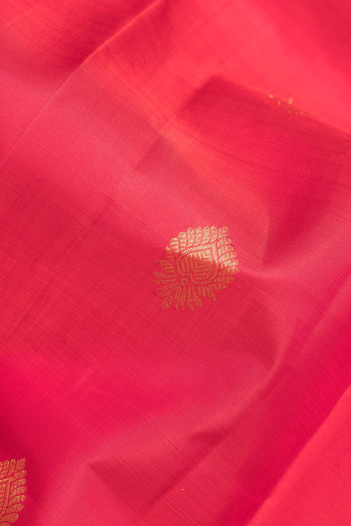 Close up of Pure Silk Red Kanchipuram Saree with Zari Butta on the body and Zari Border.  displaying folds