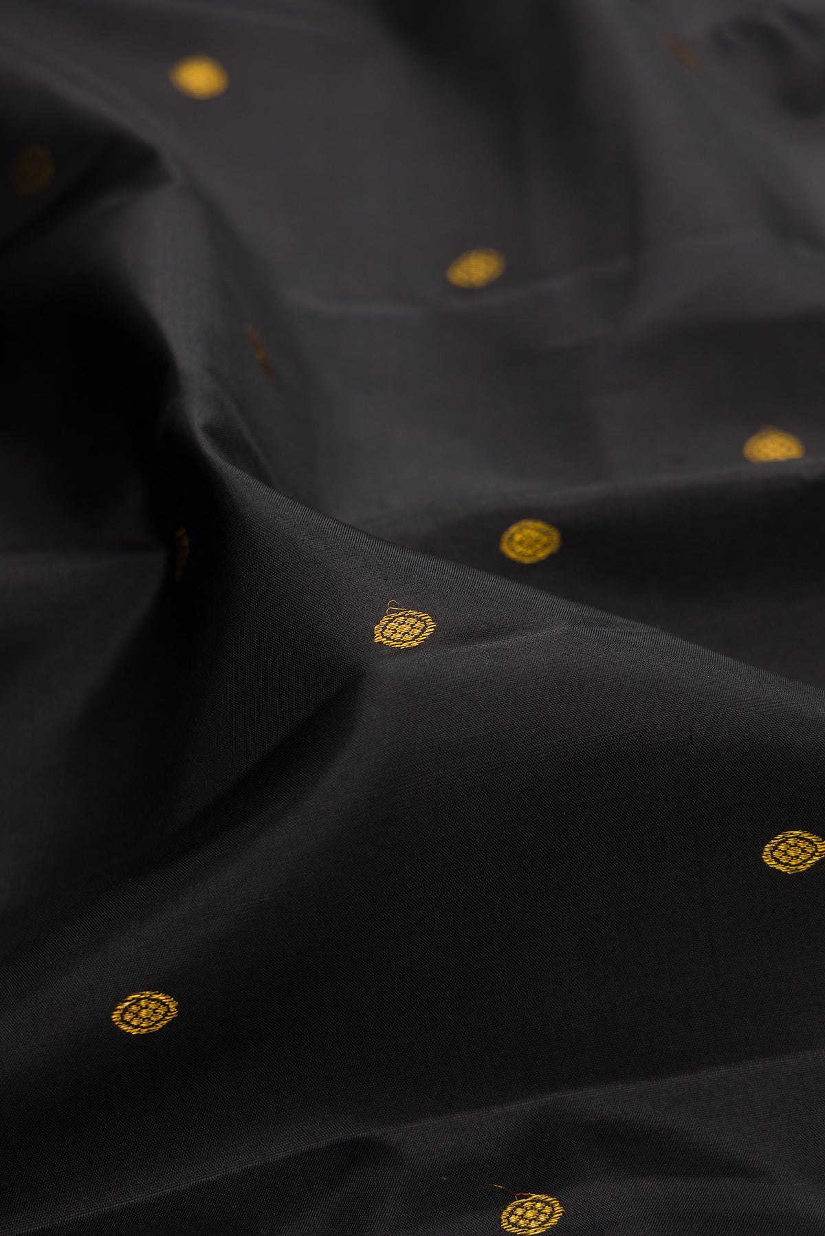 Close up of Pure Silk Black Kanjivaram Saree with Zari Butta on the body and Fancy Border.  displaying folds