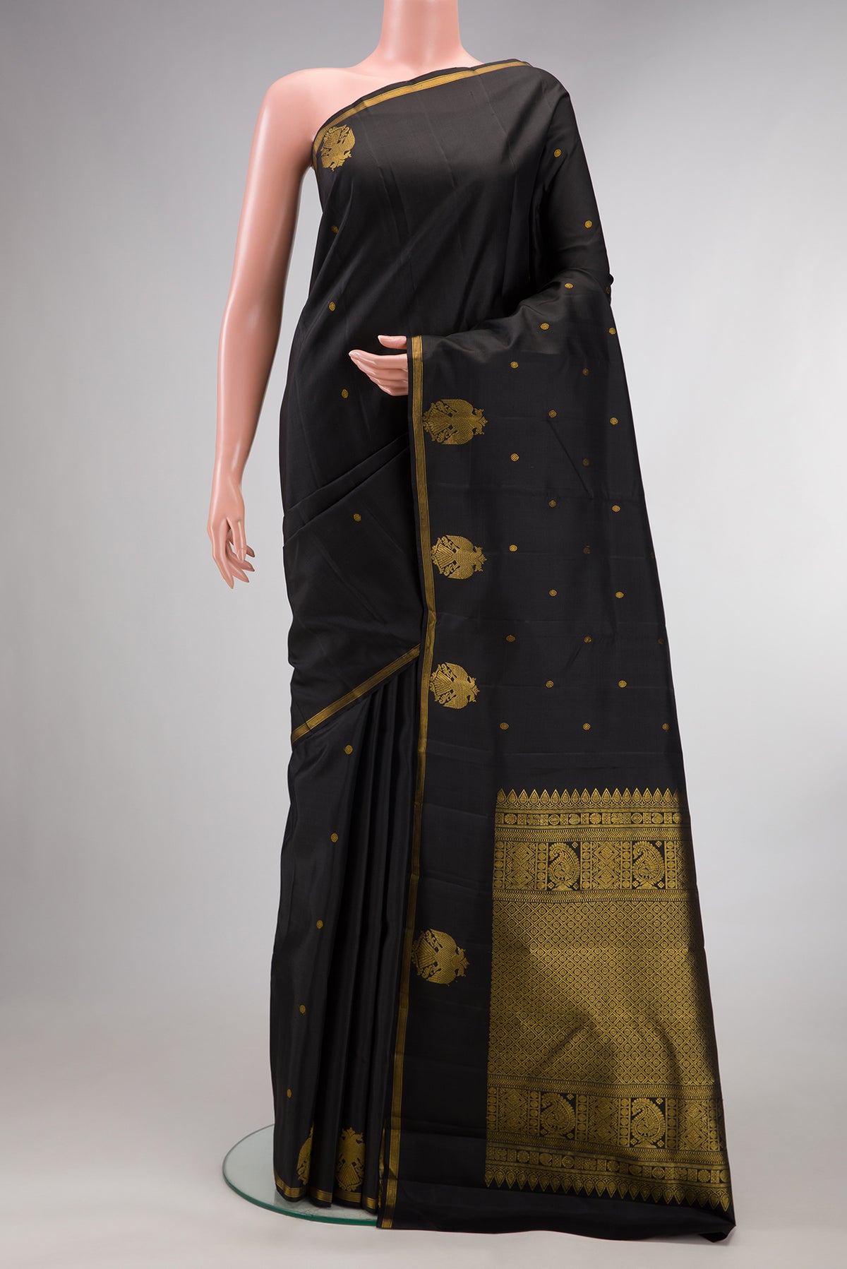 Pure Silk Black Kanjivaram Saree with Zari Butta on the body and Fancy Border.  displayed on a mannequin
