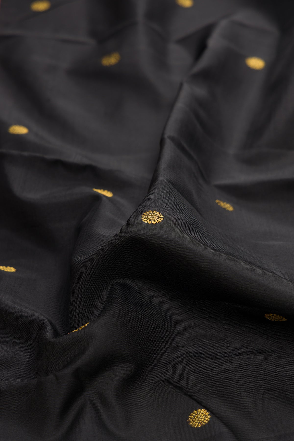 Close up of Pure Silk Black Kanjivaram Saree with Zari Butta on the body and Fancy Border.  displaying folds