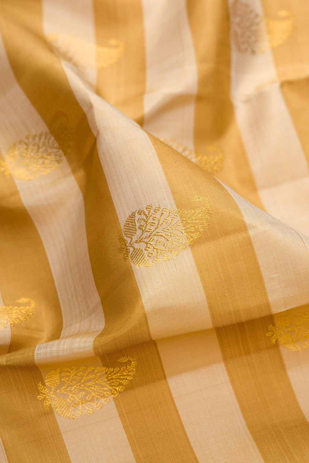 Close up of Pure Silk Mustard Kanjivaram Saree with Stripes on the body and Zari Border.  displaying folds