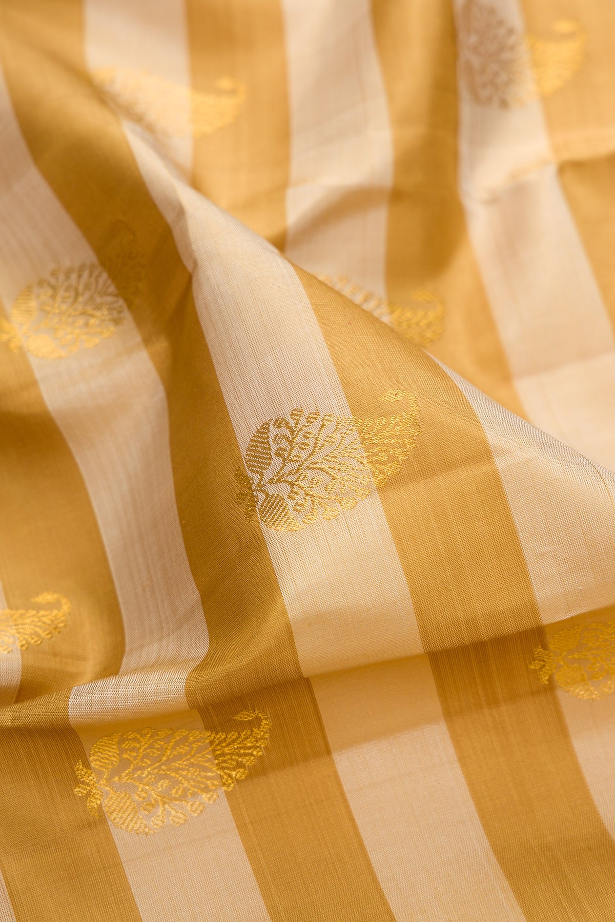 Close up of Pure Silk Mustard Kanjivaram Saree with Stripes on the body and Zari Border.  displaying folds