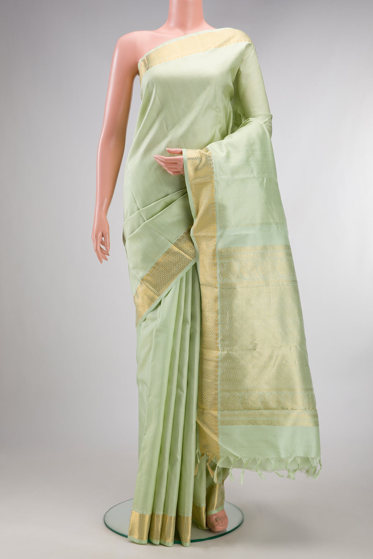 Pure Silk Pista Green Kanjivaram Saree with Checked design on the body and Zari Border.  displayed on a mannequin