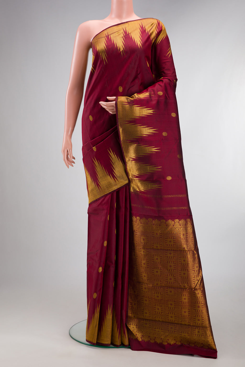 Pure Silk Maroon Kanjivaram Saree with Zari Butta on the body and Temple Border.  displayed on a mannequin