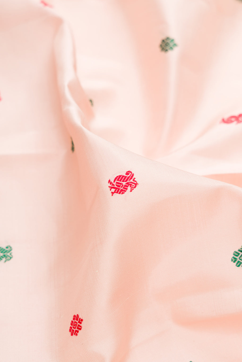 Close up of Pure Silk Rose Gold Kanjivaram Saree with Thread Butta on the body and Zari Border.  displaying folds
