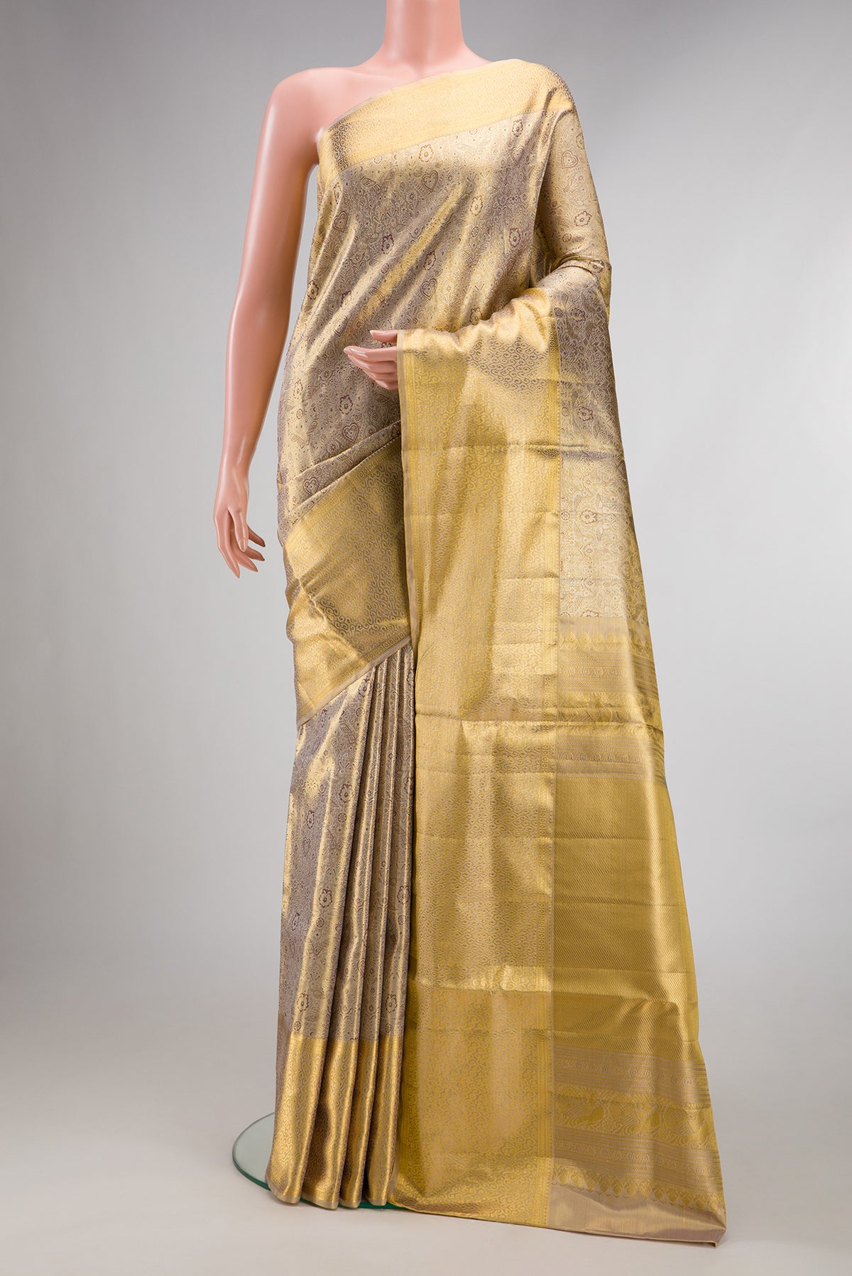 Gold Dual Tone Kanjivaram Tissue Saree with Zari Brocade on the body and Zari Border.  displayed on a mannequin