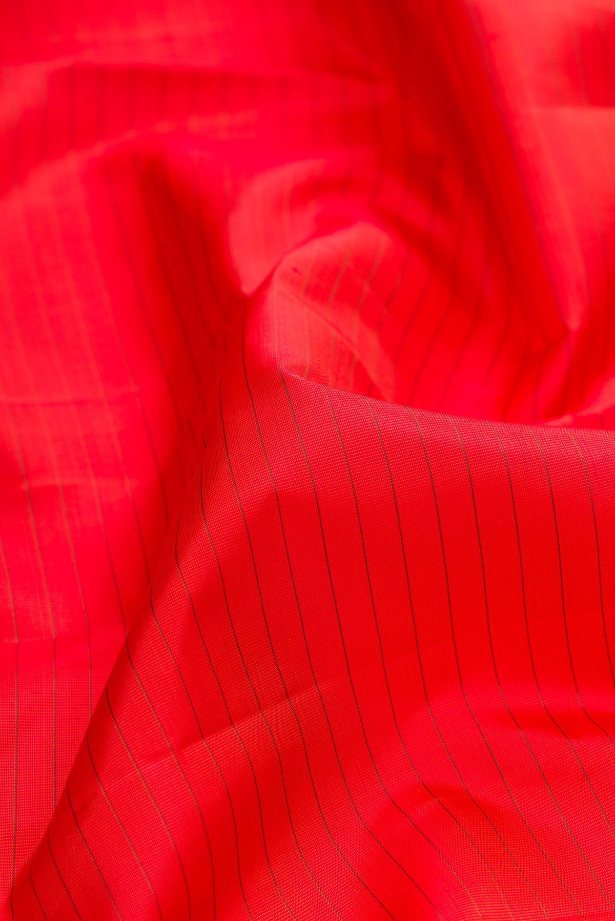 Close up of Pure Silk Brick Orange Dual Tone Kanchipuram Saree with Stripes on the body and Zari Border.  displaying folds