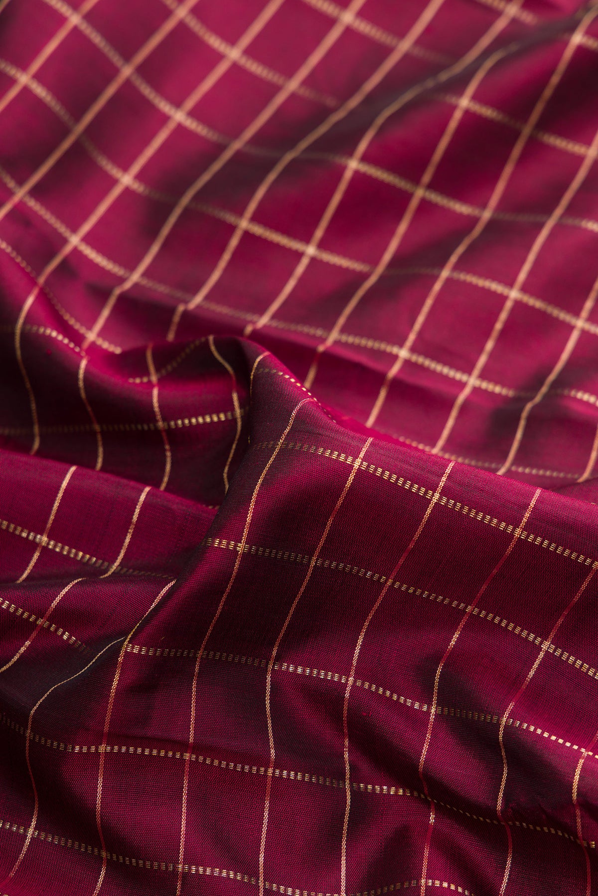Close up of Pure Silk Maroon Kanjivaram Saree with Checked design on the body and Zari Border.  displaying folds