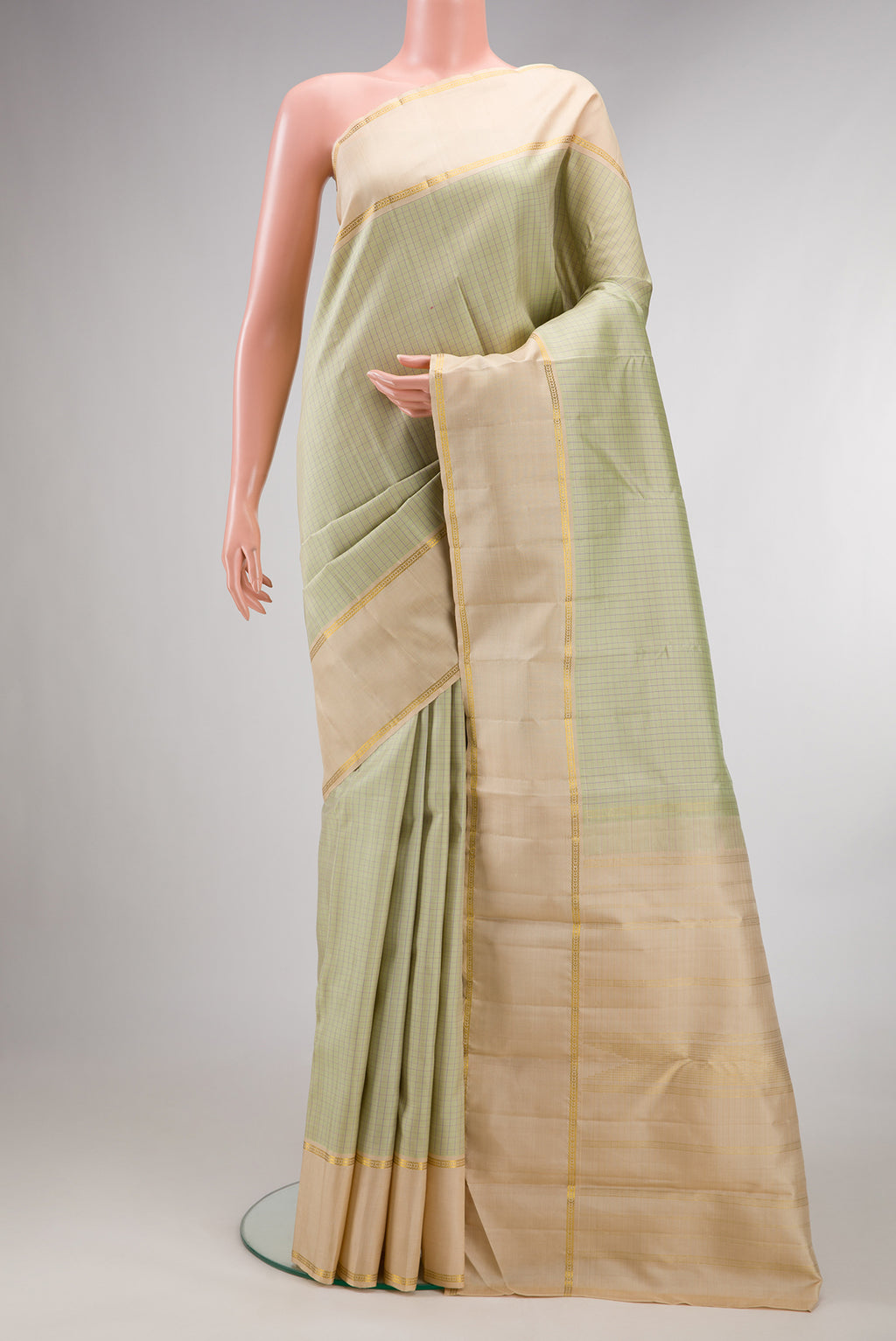 Pure Silk Pista Green Kanchipuram Saree with Checked design on the body and Plain Border.  displayed on a mannequin