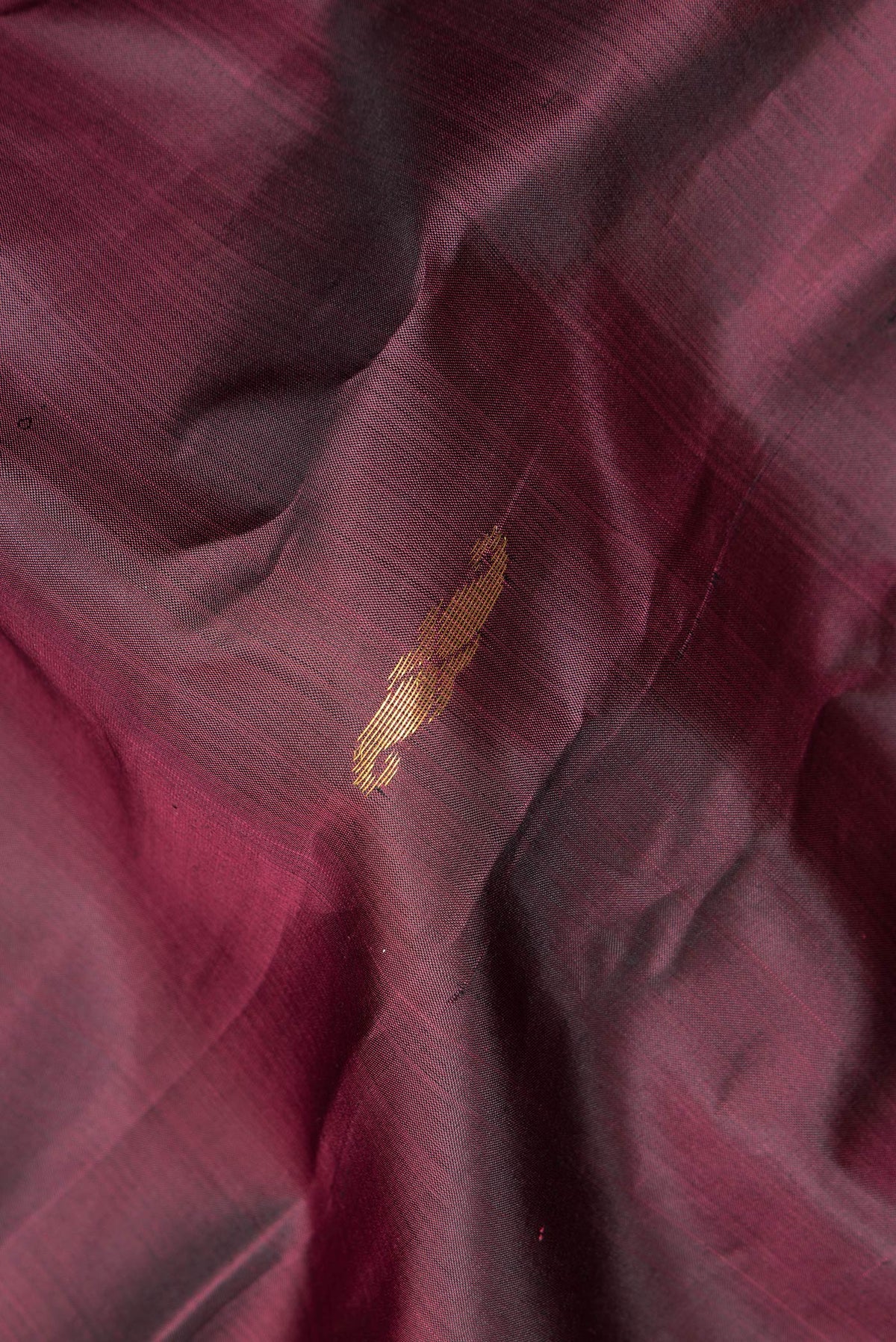 Close up of Pure Silk Maroon Dual Tone Kanchipuram Saree with Zari Butta on the body and Fancy Border.  displaying folds