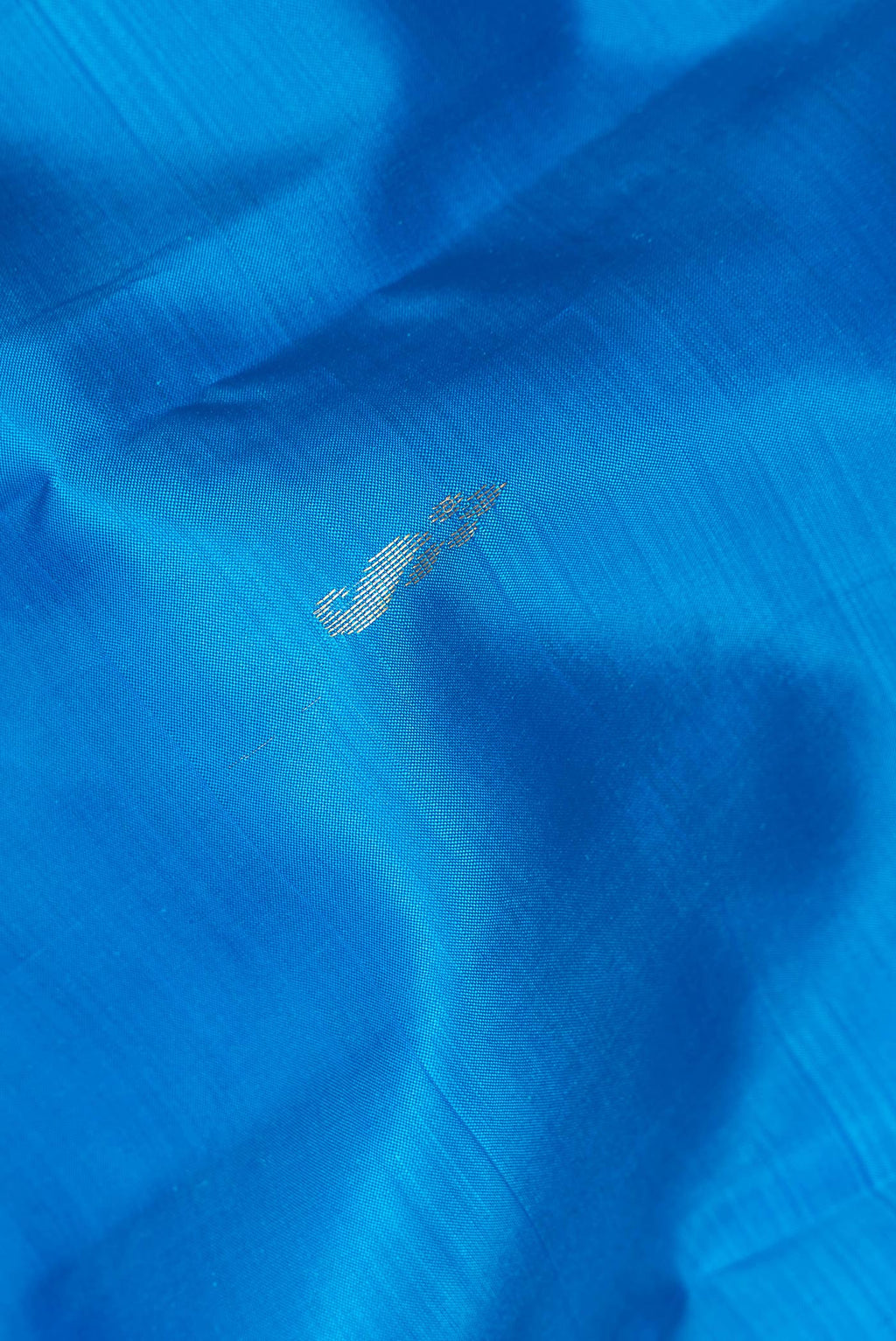 Close up of Pure Silk Sky Blue Dual Tone Kanchipuram Saree with Zari Butta on the body and Fancy Border.  displaying folds