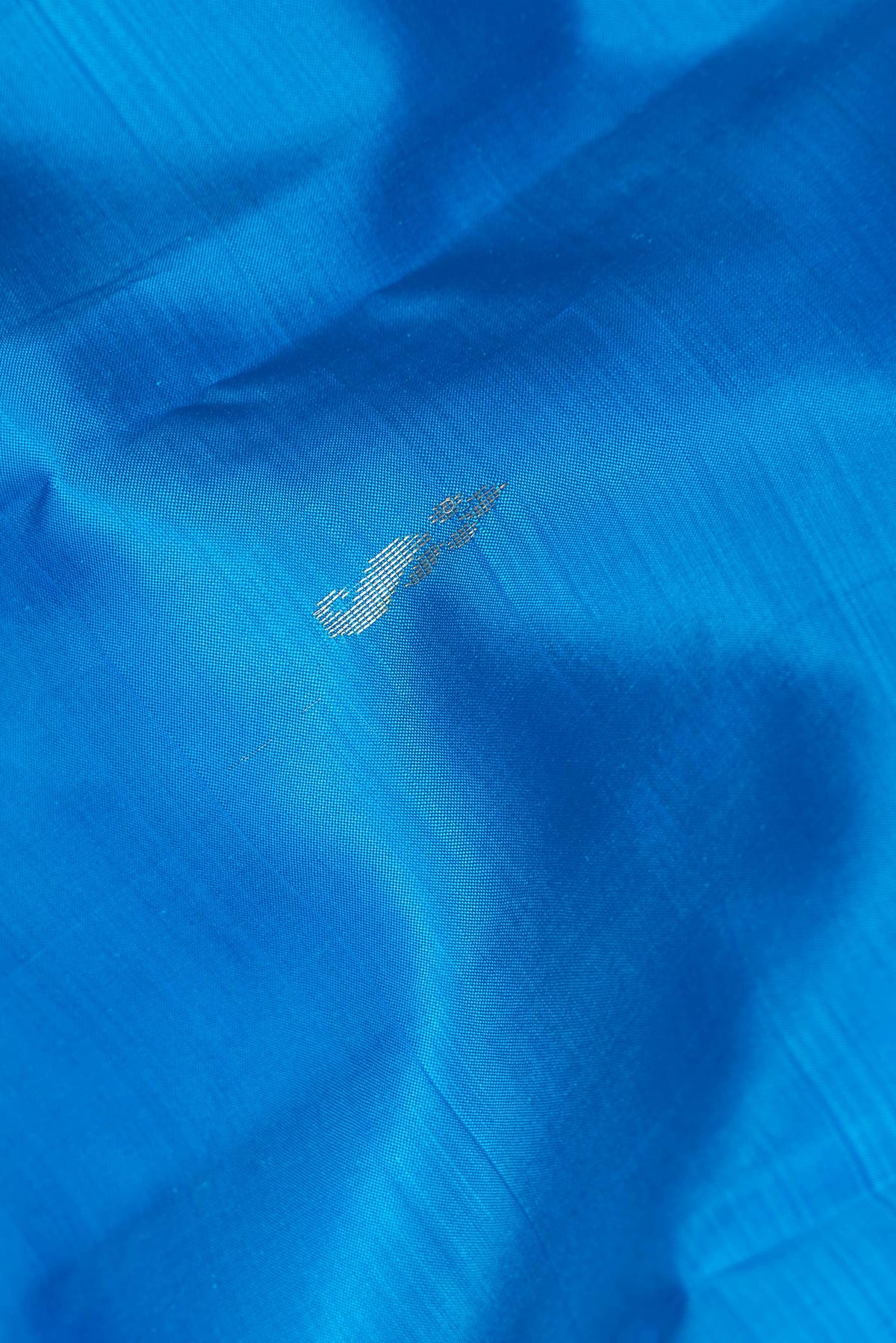 Close up of Pure Silk Sky Blue Dual Tone Kanchipuram Saree with Zari Butta on the body and Fancy Border.  displaying folds