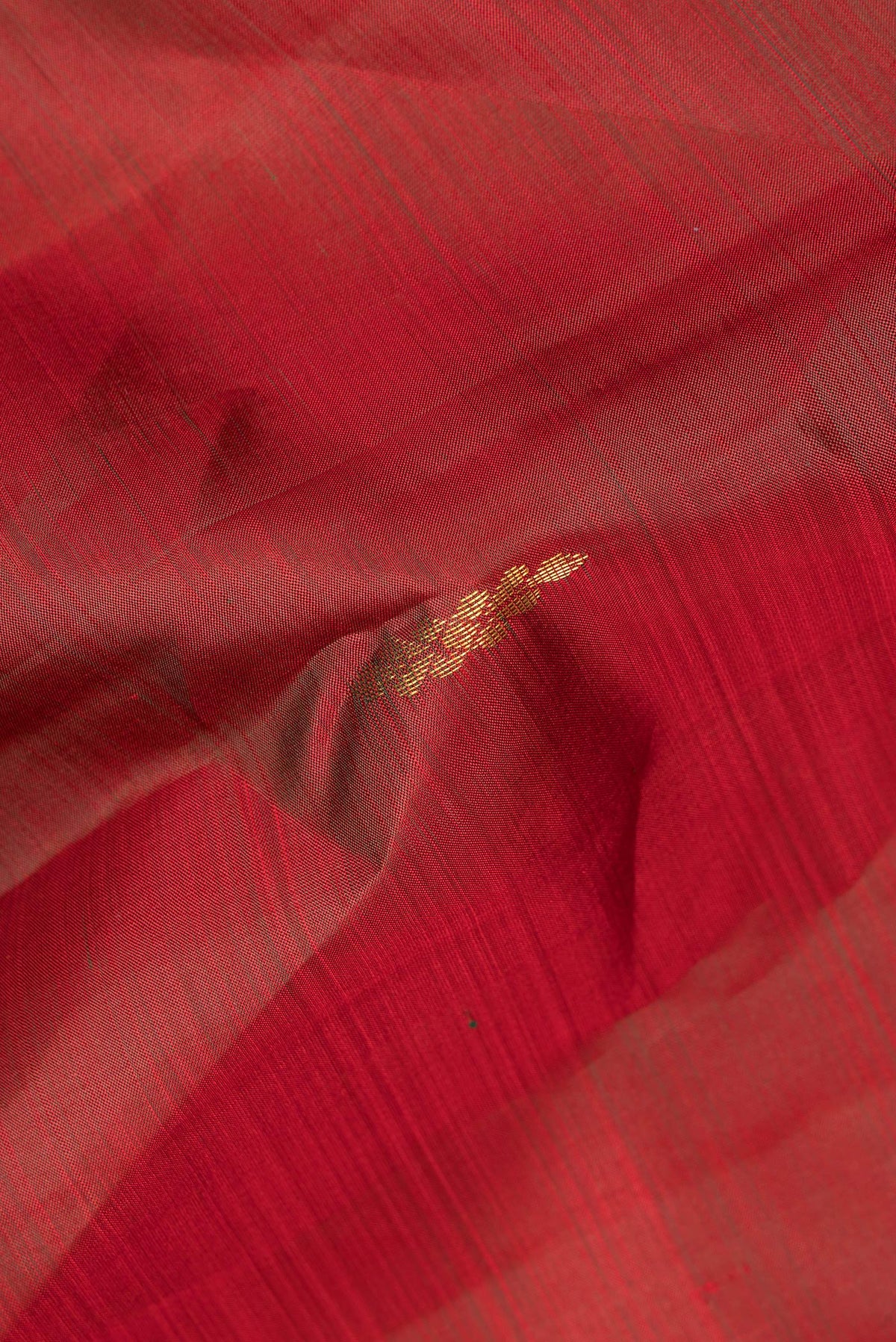 Close up of Pure Silk Rust Dual Tone Kanchipuram Saree with Zari Butta on the body and Fancy Border.  displaying folds