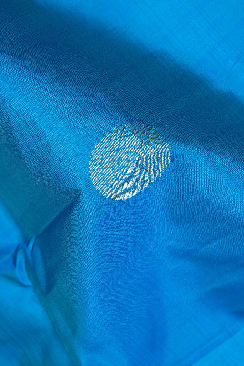 Close up of Pure Silk Sky Blue Dual Tone Kanchipuram Saree with Zari Butta on the body and Fancy Border.  displaying folds