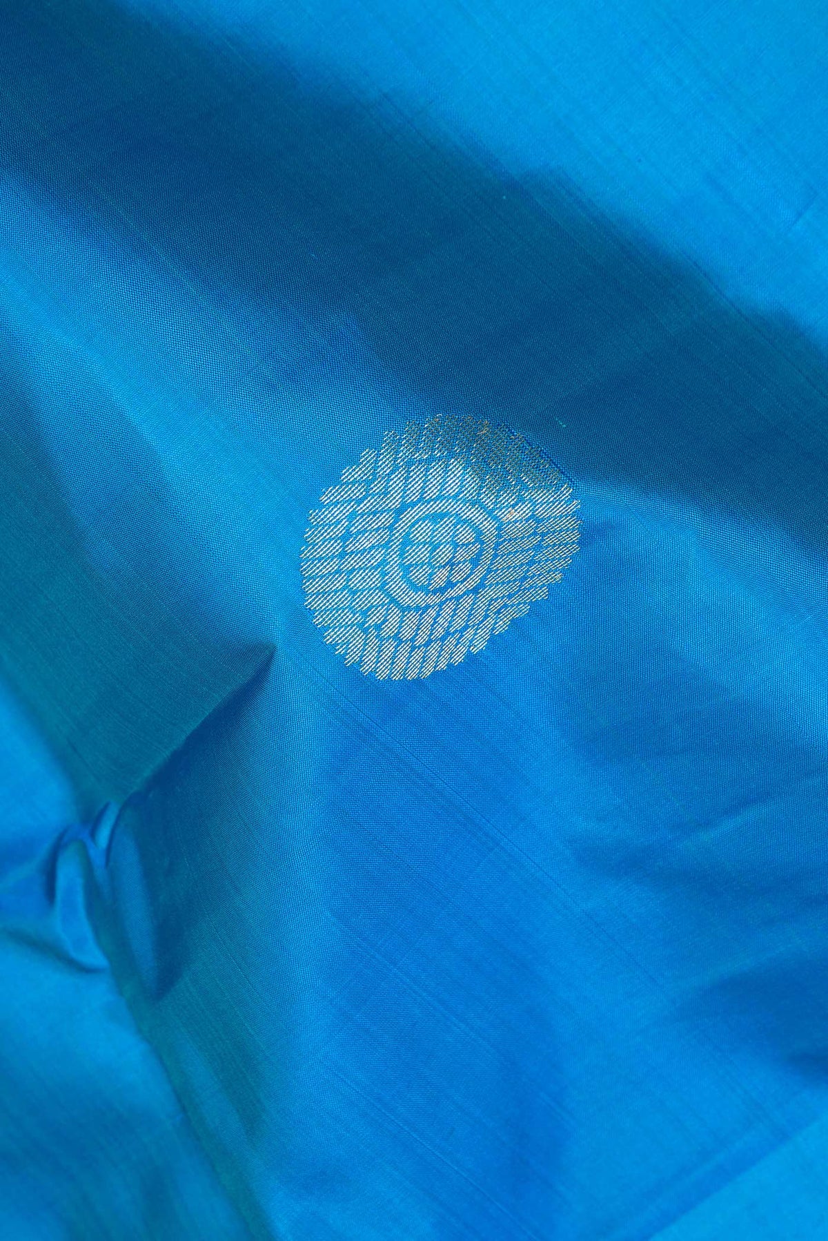 Close up of Pure Silk Sky Blue Dual Tone Kanchipuram Saree with Zari Butta on the body and Fancy Border.  displaying folds