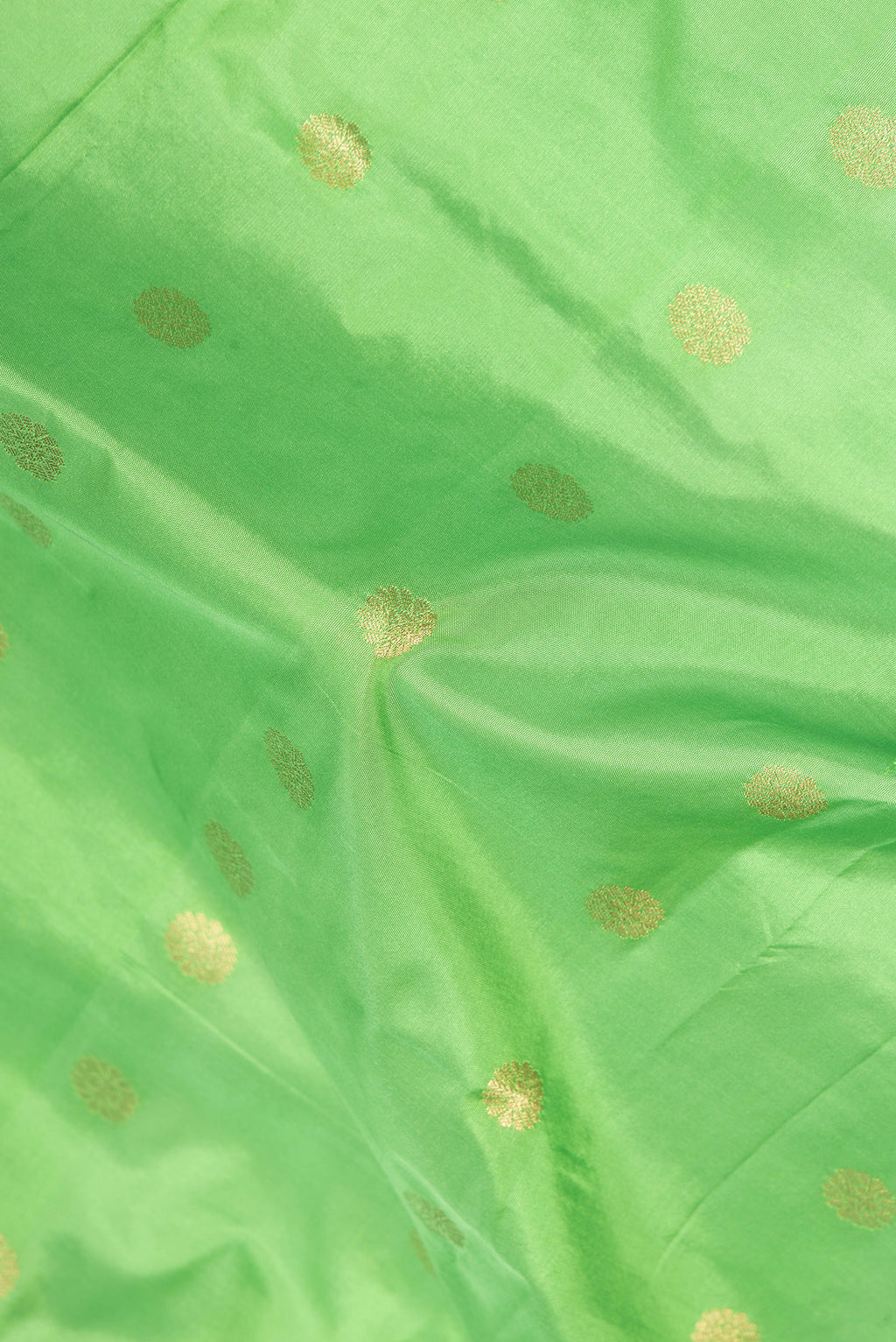 Close up of Parrot Green Blended Paithani Silk Saree with Zari Butta on the body and Zari Border.  displaying folds