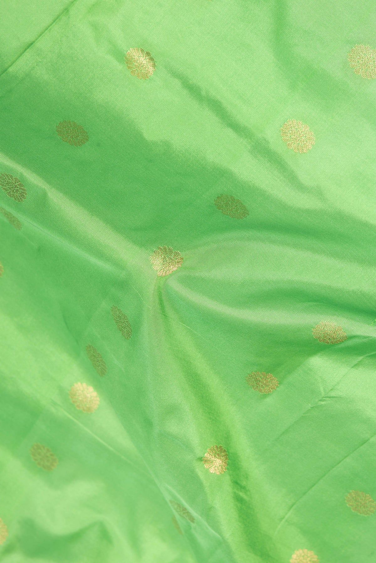Close up of Parrot Green Blended Paithani Silk Saree with Zari Butta on the body and Zari Border.  displaying folds
