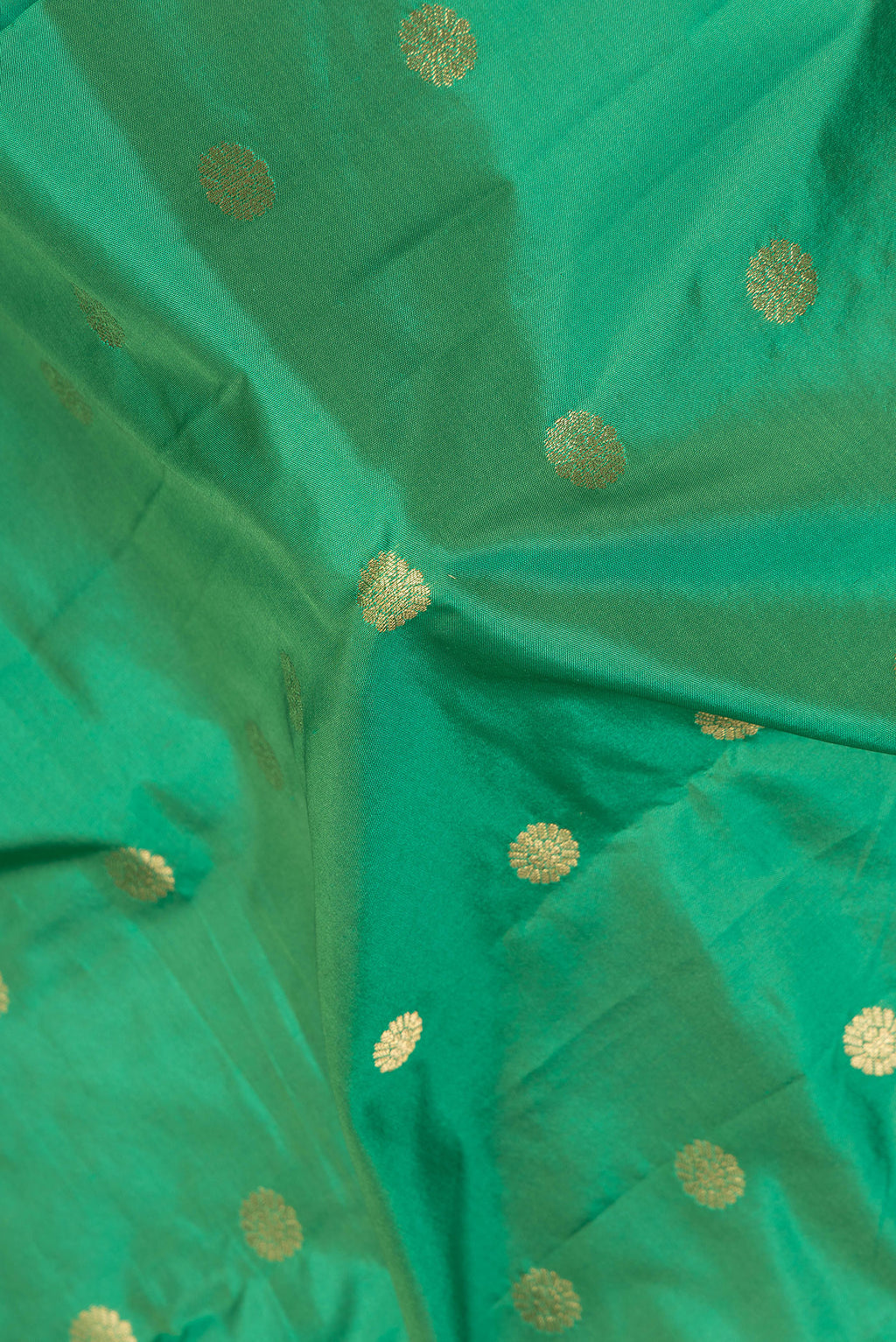 Close up of Green Blended Paithani Silk Saree with Zari Butta on the body and Zari Border.  displaying folds