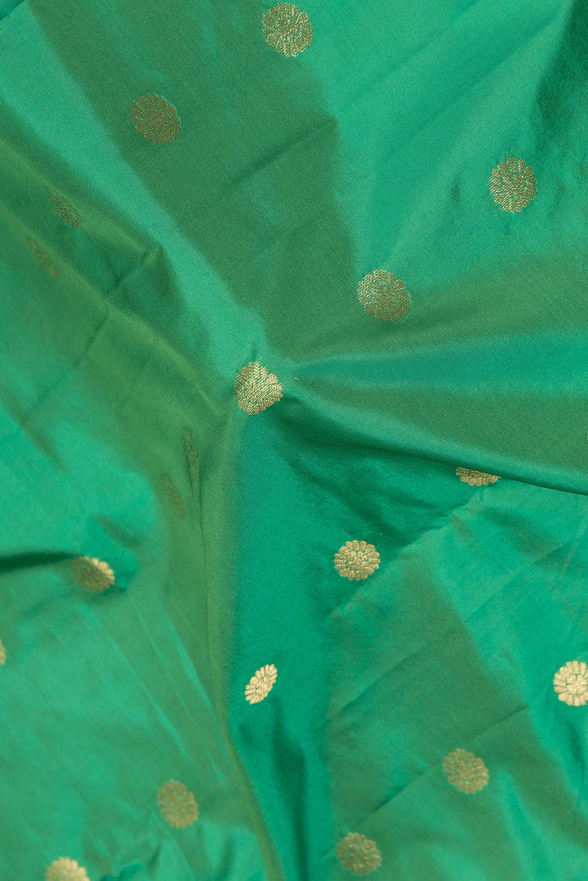 Close up of Green Blended Paithani Silk Saree with Zari Butta on the body and Zari Border.  displaying folds