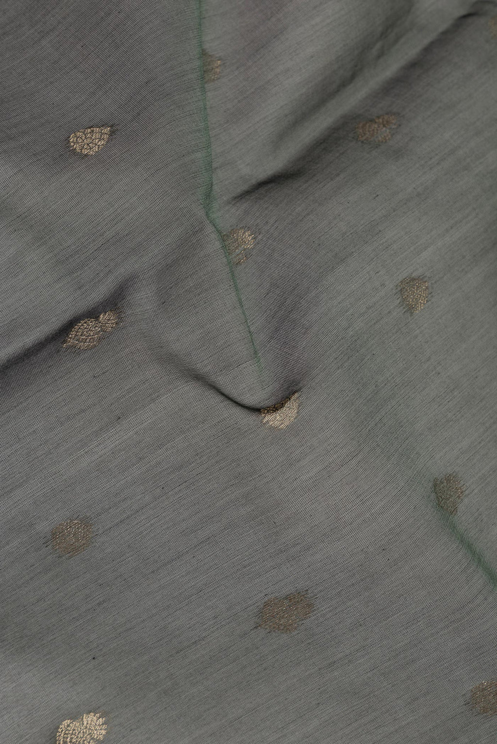Close up of Green Silk Cotton Saree with Zari Butta on the body and Zari Border.  displaying folds
