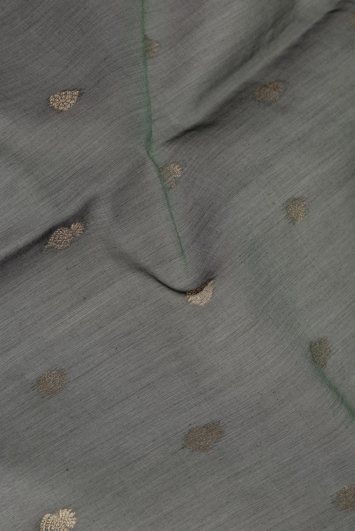 Close up of Green Silk Cotton Saree with Zari Butta on the body and Zari Border.  displaying folds