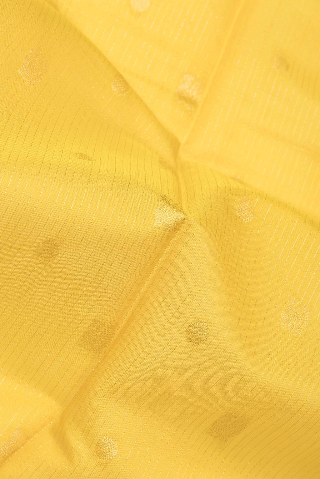 Close up of Yellow Silk Cotton Saree with Zari Butta on the body and Zari Border.  displaying folds