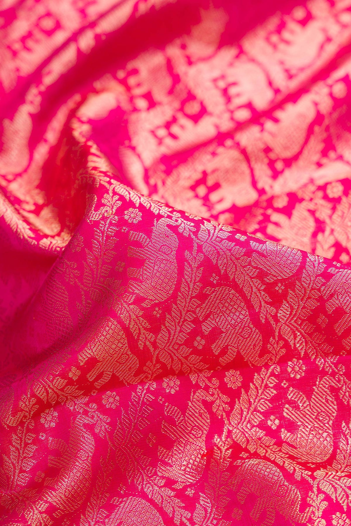 Close up of Pure Silk Dark Pink Dual Tone Kanchipuram Saree with Zari Brocade on the body and Zari Border.  displaying folds
