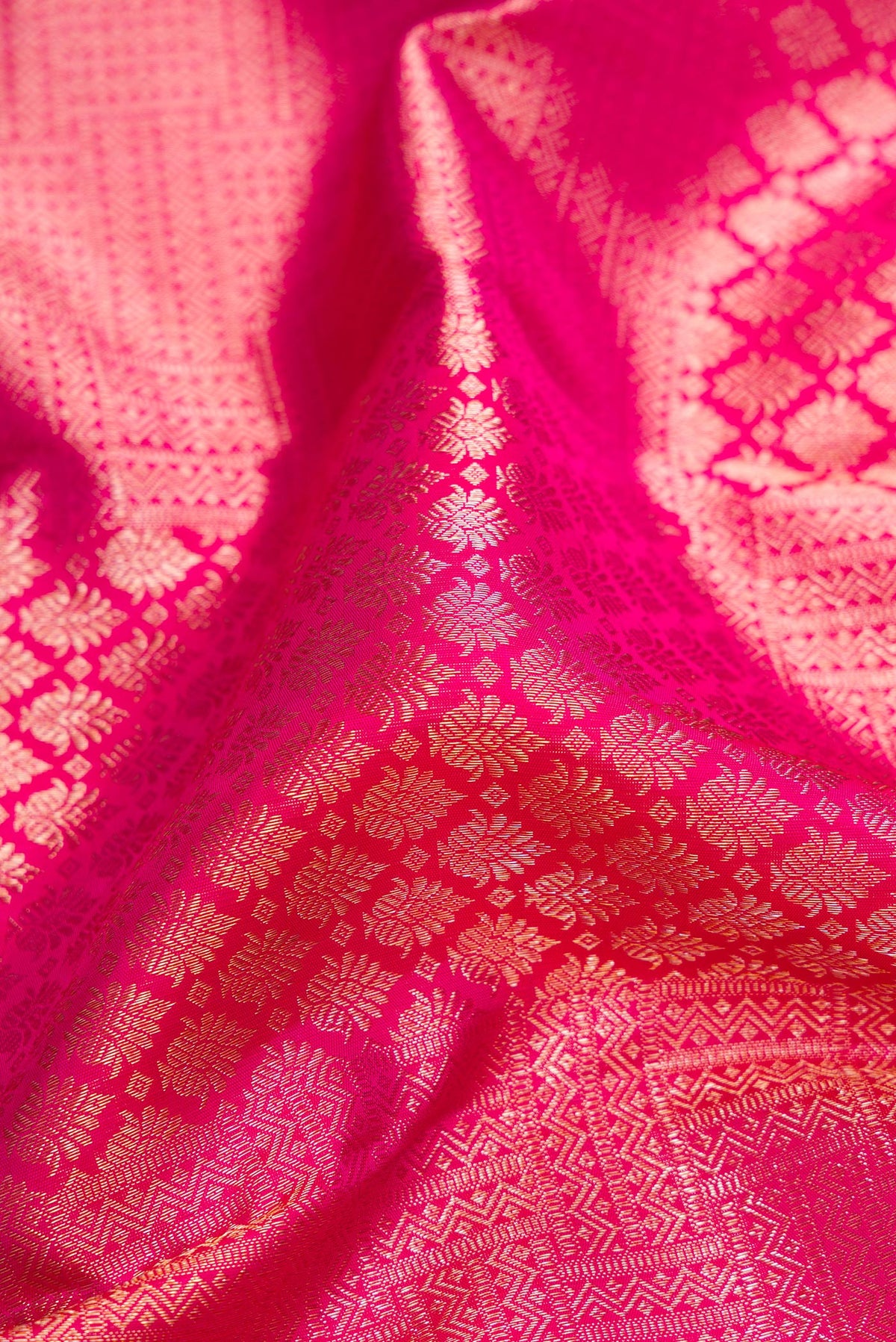 Close up of Pure Silk Pink Kanchipuram Saree with Zari Brocade on the body and Fancy Border.  displaying folds